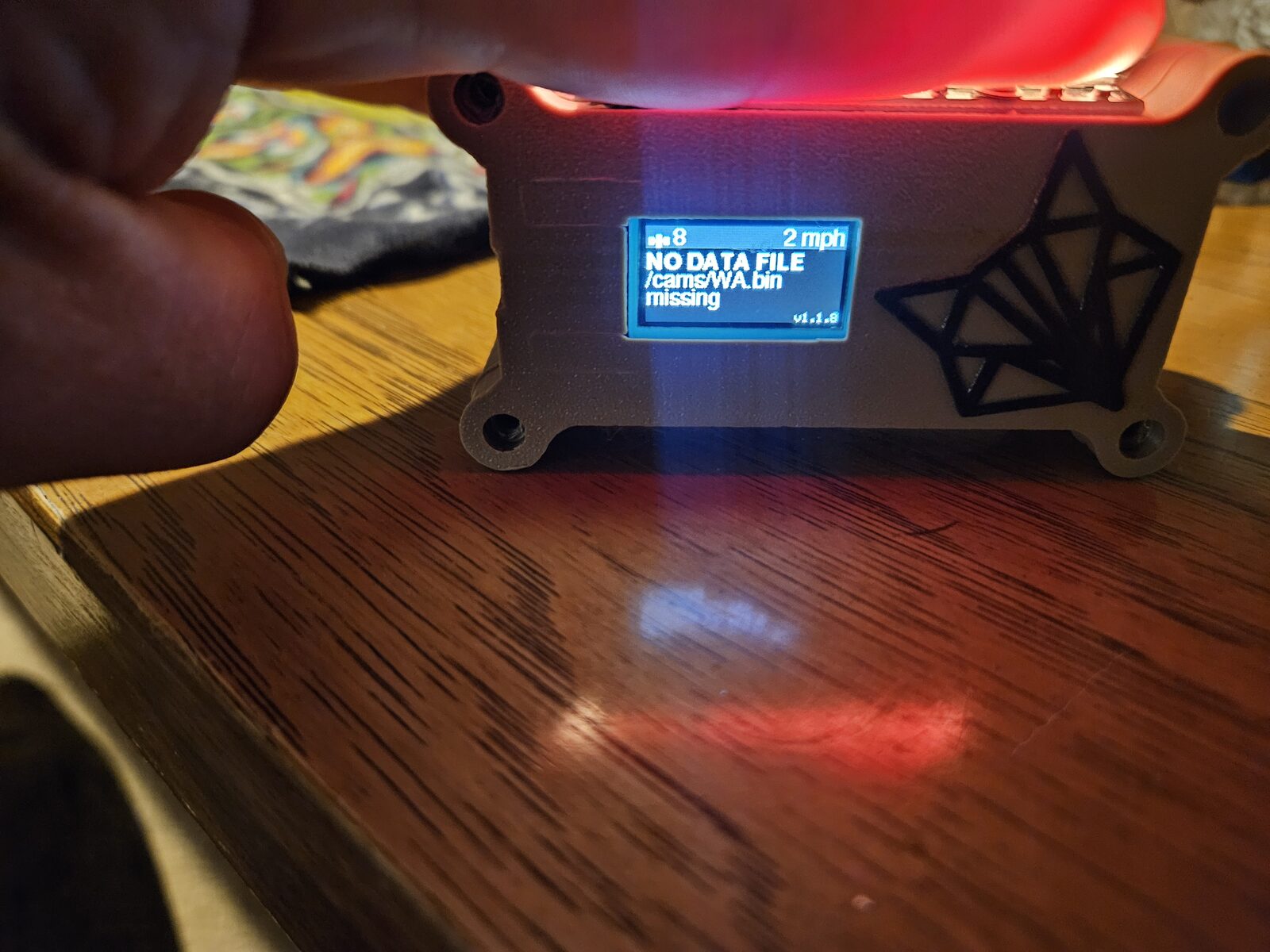 The FlockU device by CyberSasquatch, a small board with an OLED reading 'cams/WA.bin missing' and a wireframe fox logo.